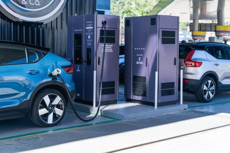 Carro elétrico conectado a uma estação de recarga em eletroposto