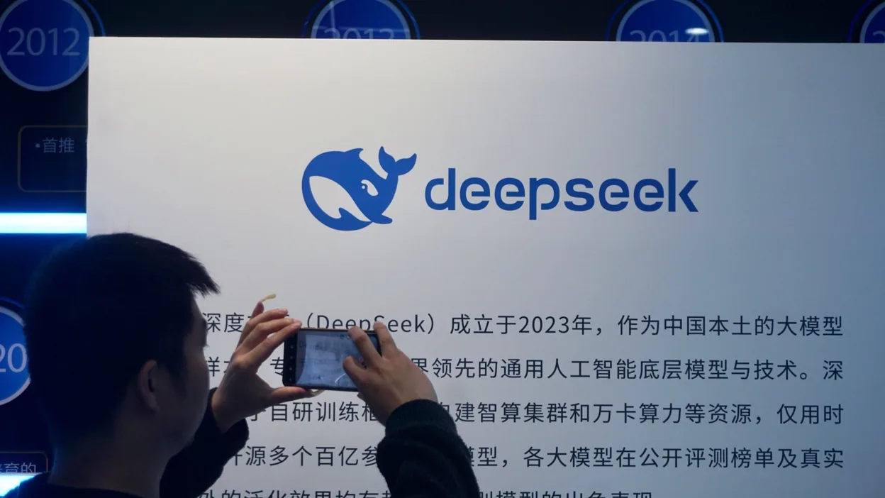 Logotipo da DeepSeek exibido em uma tela com elementos visuais relacionados a modelos de inteligência artificial e processamento de dados.