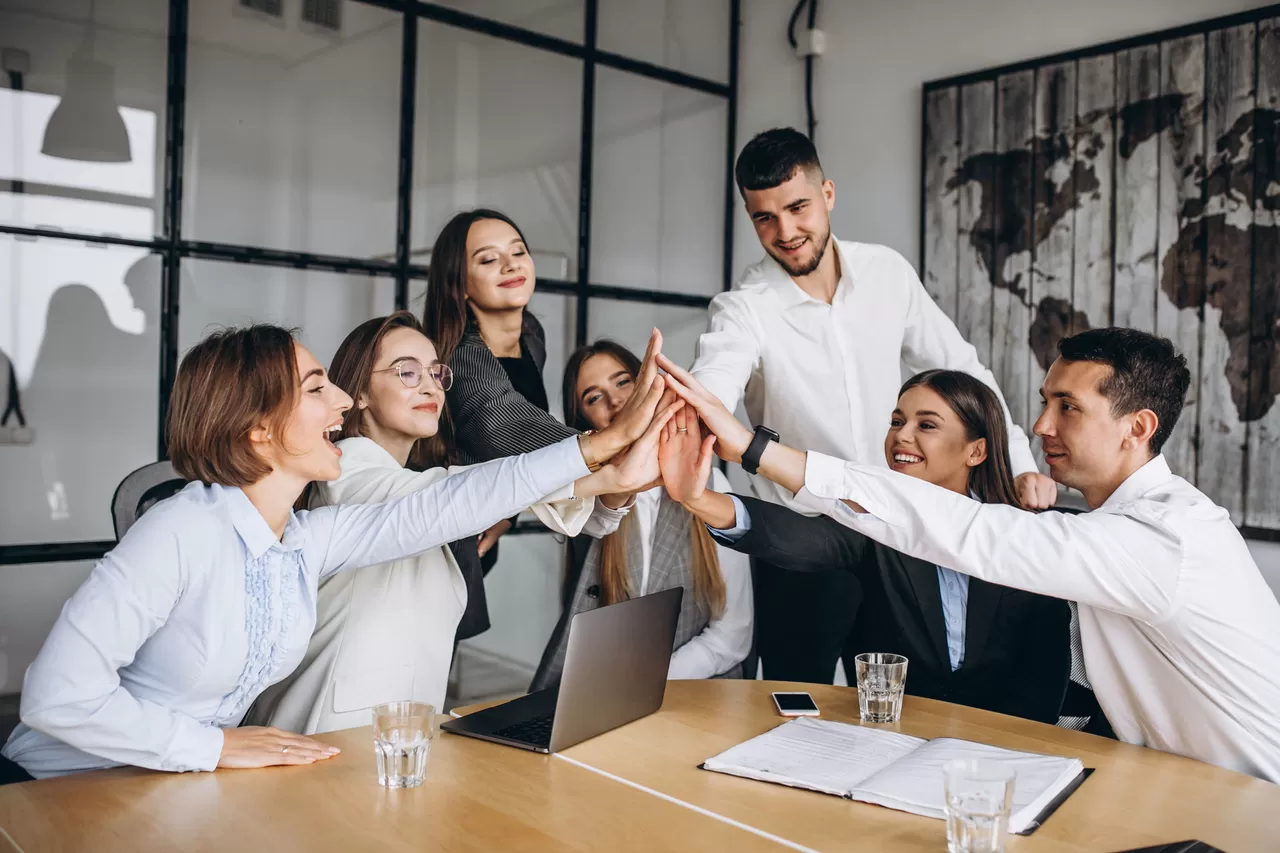 Profissionais reunidos em ambiente de trabalho durante conversa e reconhecimento de resultados da equipe